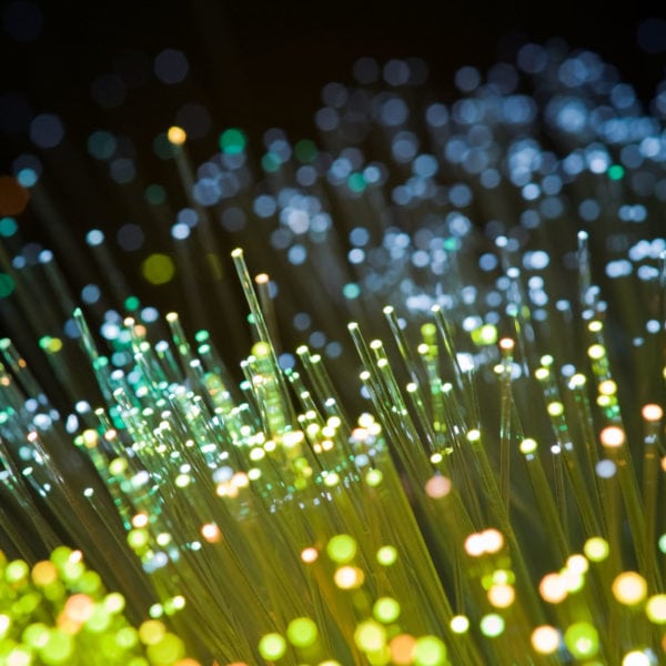 Picture of illuminated fiber optic cables illustrating cybersecurity.